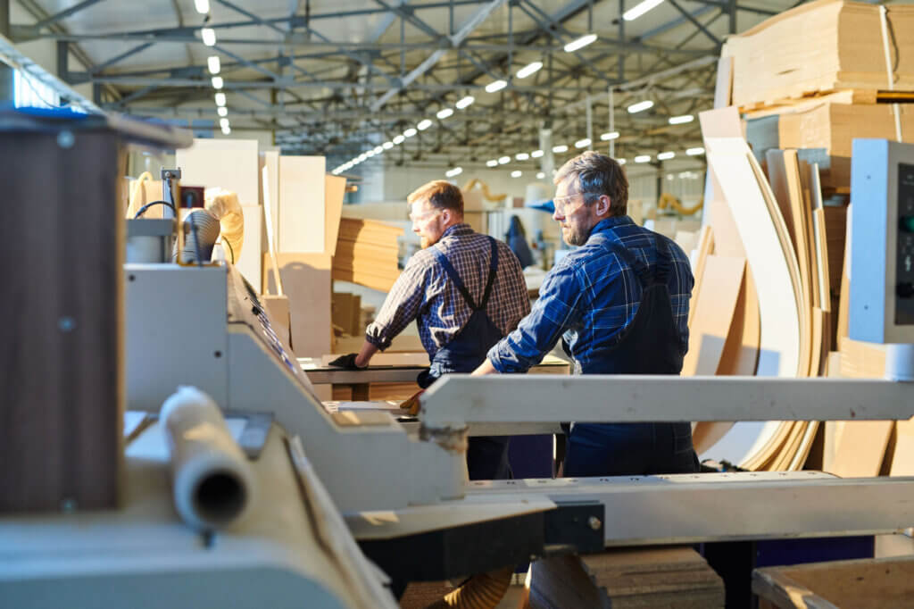 Two male industrial manufacturer workers in assembly shop.