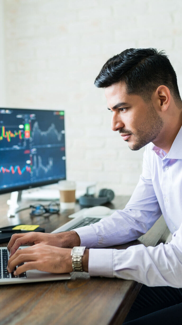 Investor professional working on a laptop at a desk