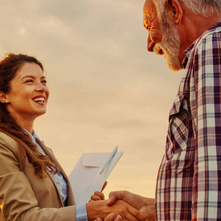 A male farmer is doing a commercial real estate loan with his broker.