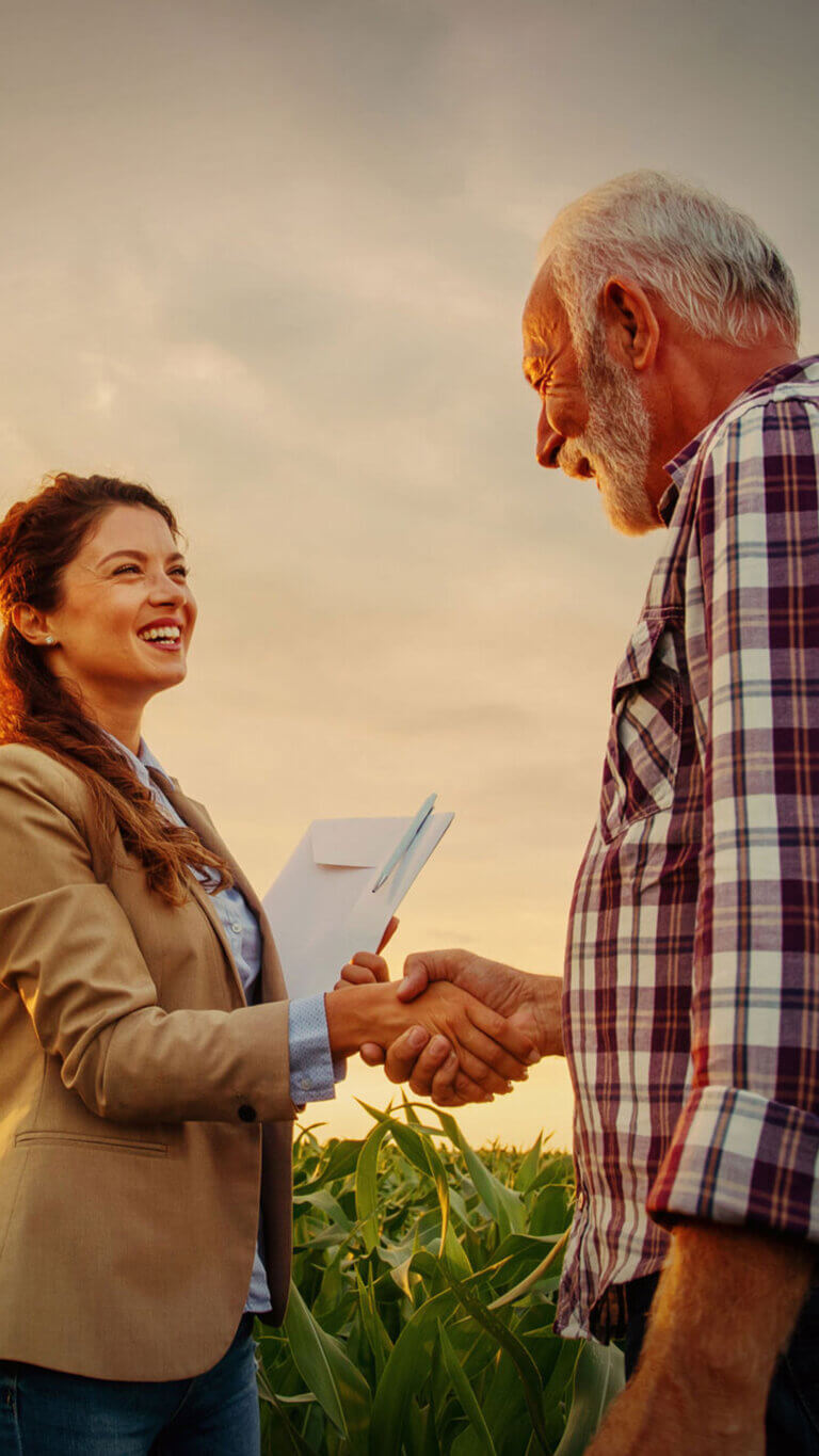 Male farmer shaking hands with his USDA business loans specialist.