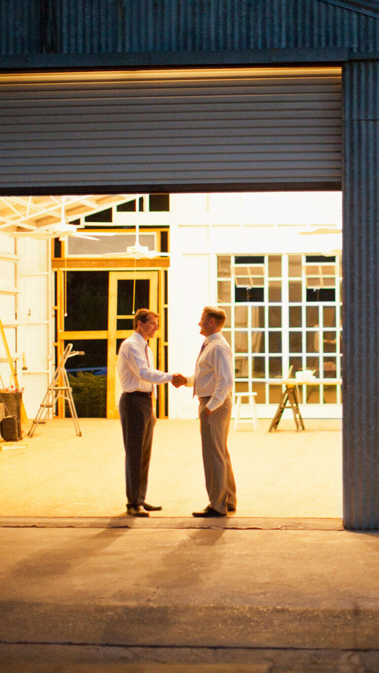 two business men shaking hands who are using sba small business loans to grow their company