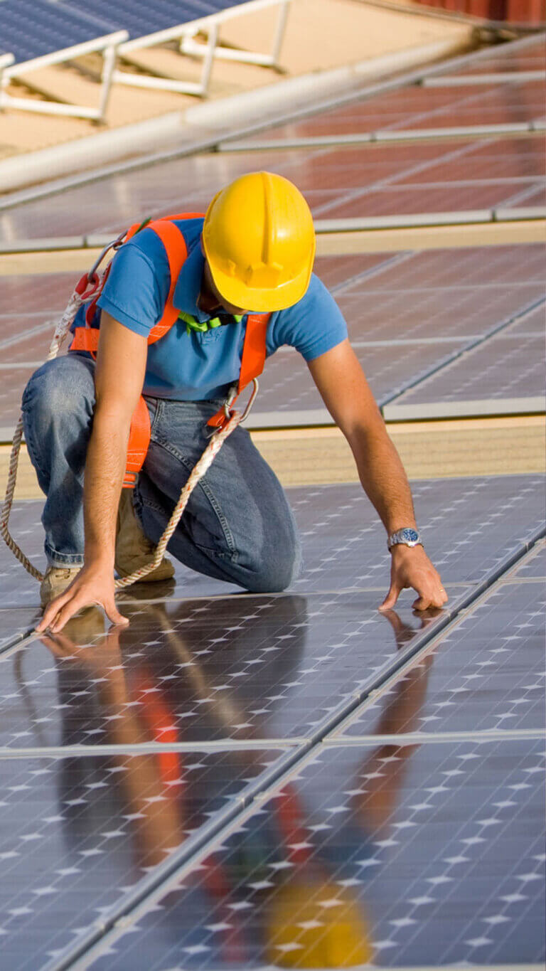 worker installing solar panels funded by the usda rural energy for america program