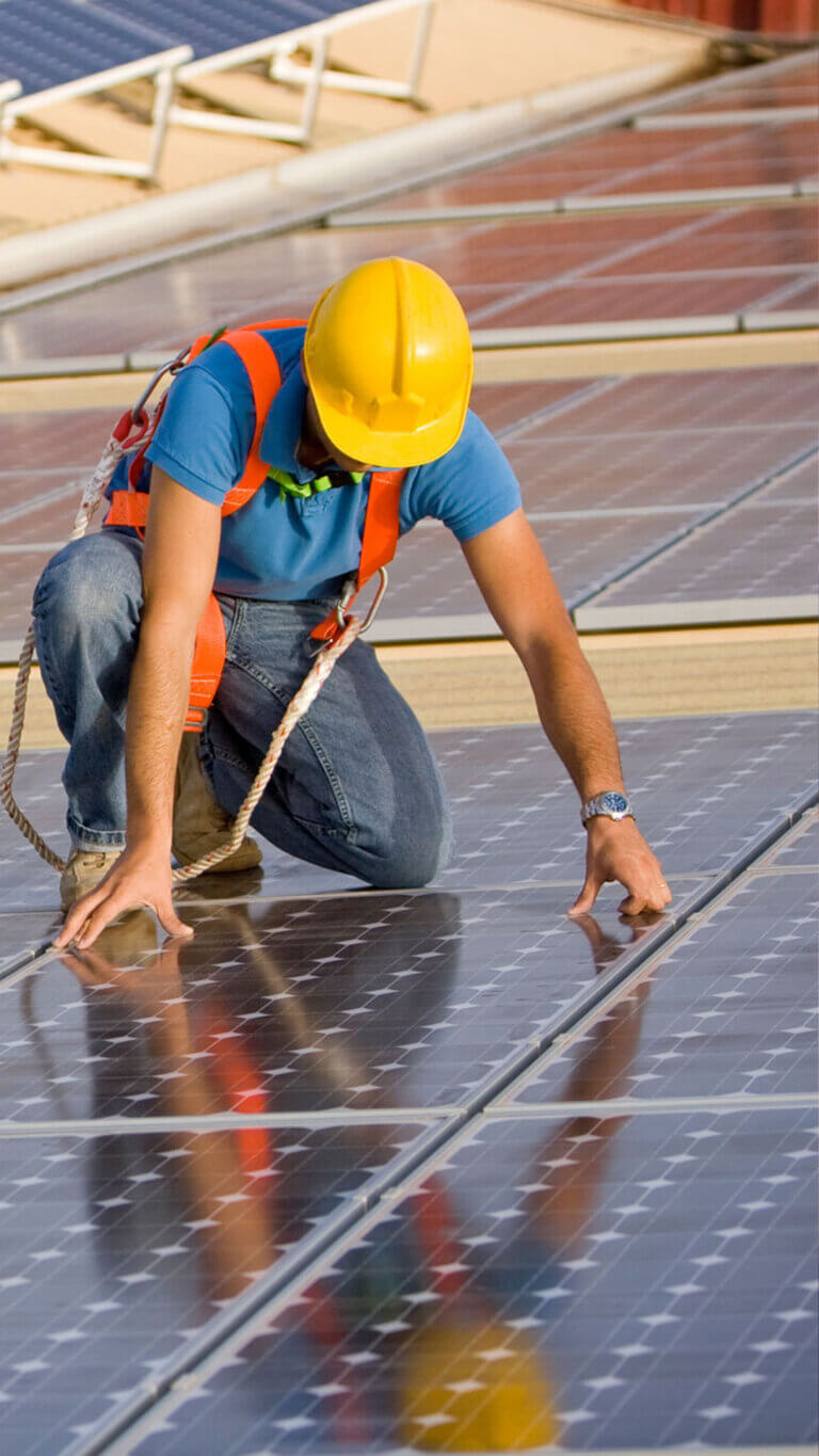 worker installing solar panels funded by the usda rural energy for america program