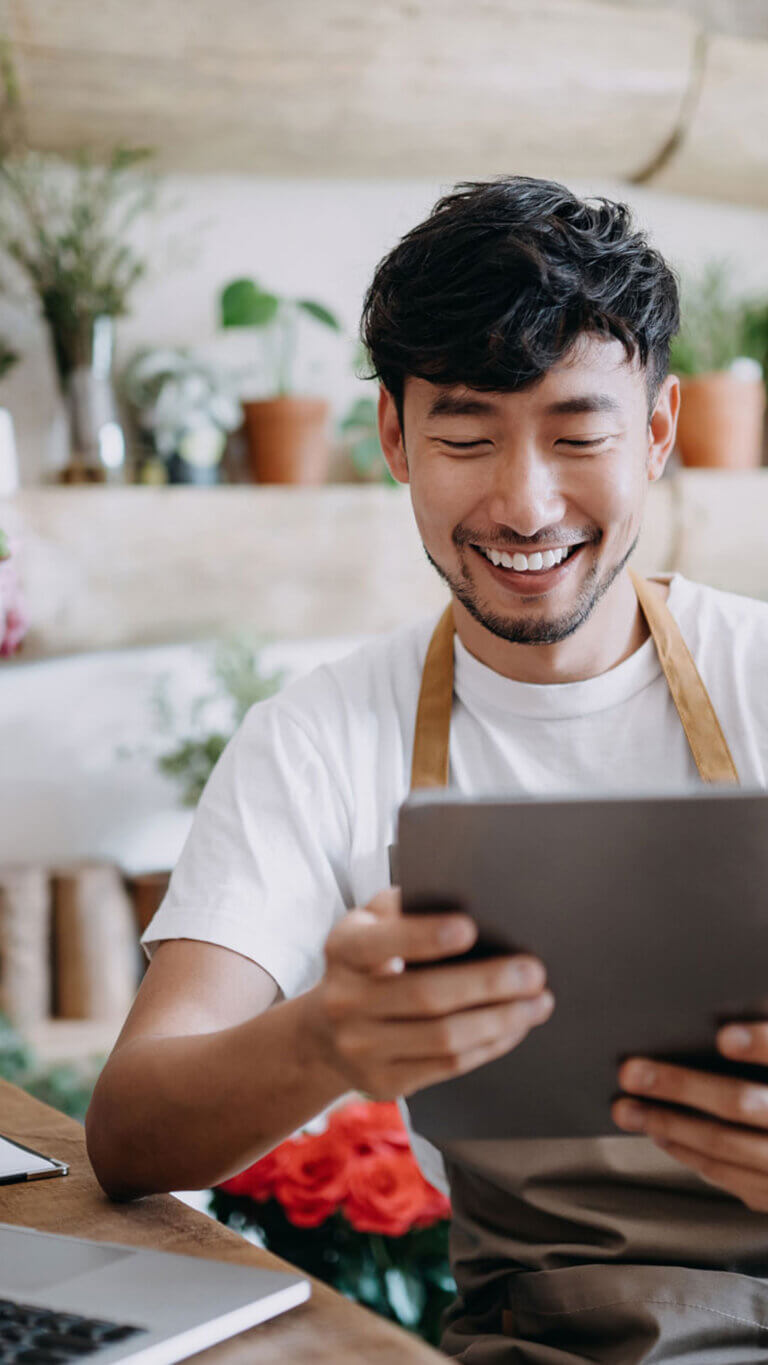 Small business florist reviewing commercial loan approval on tablet.