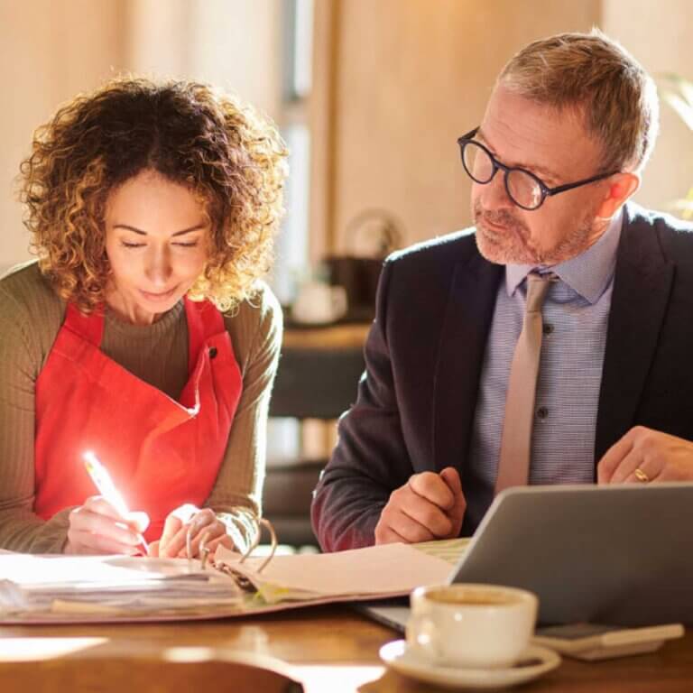 Small business owner working with commercial loan expert on document checklist