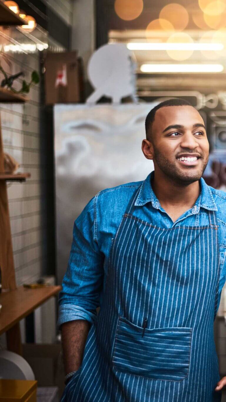 small business owner standing happily in his business
