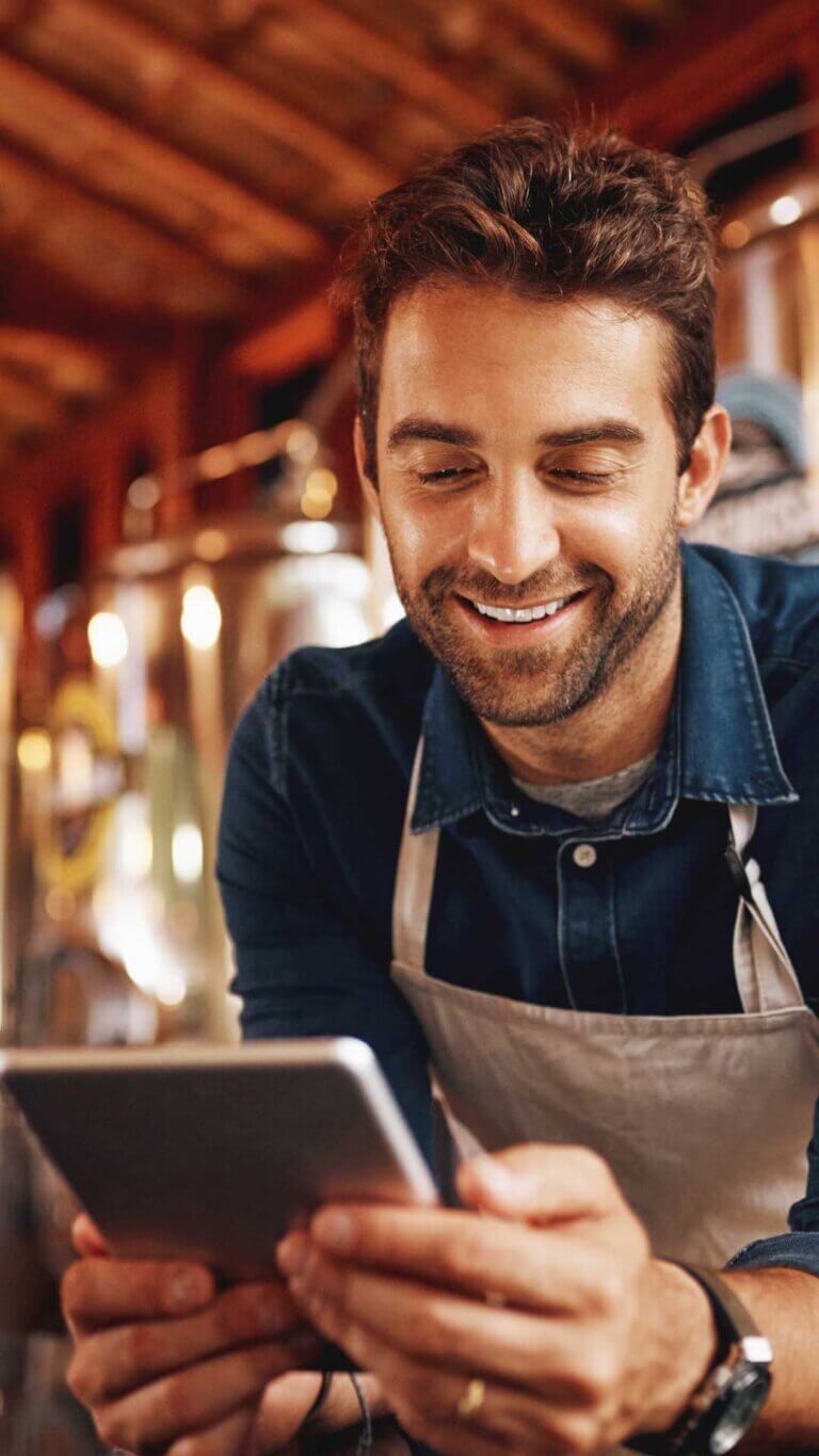 Small business owner man on tablet looking at his business plan