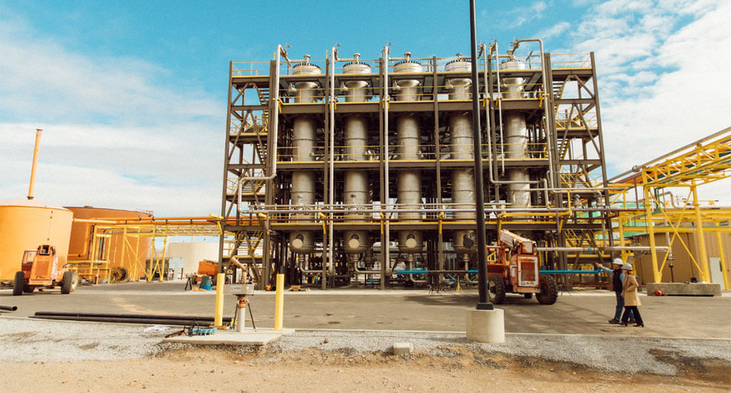 Two people walking in front of refinery at New Rise Reno