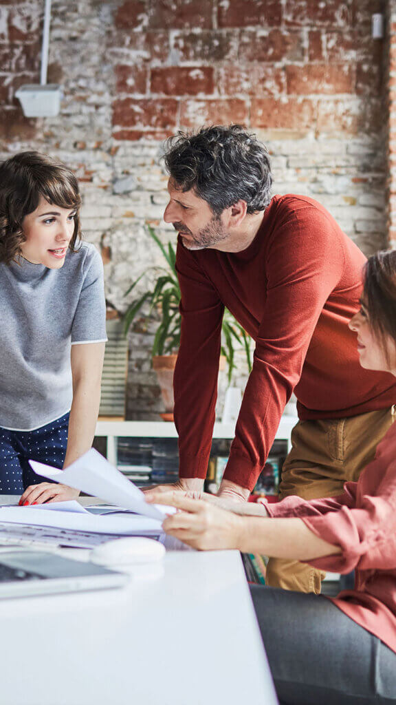 Group of three employees talking together