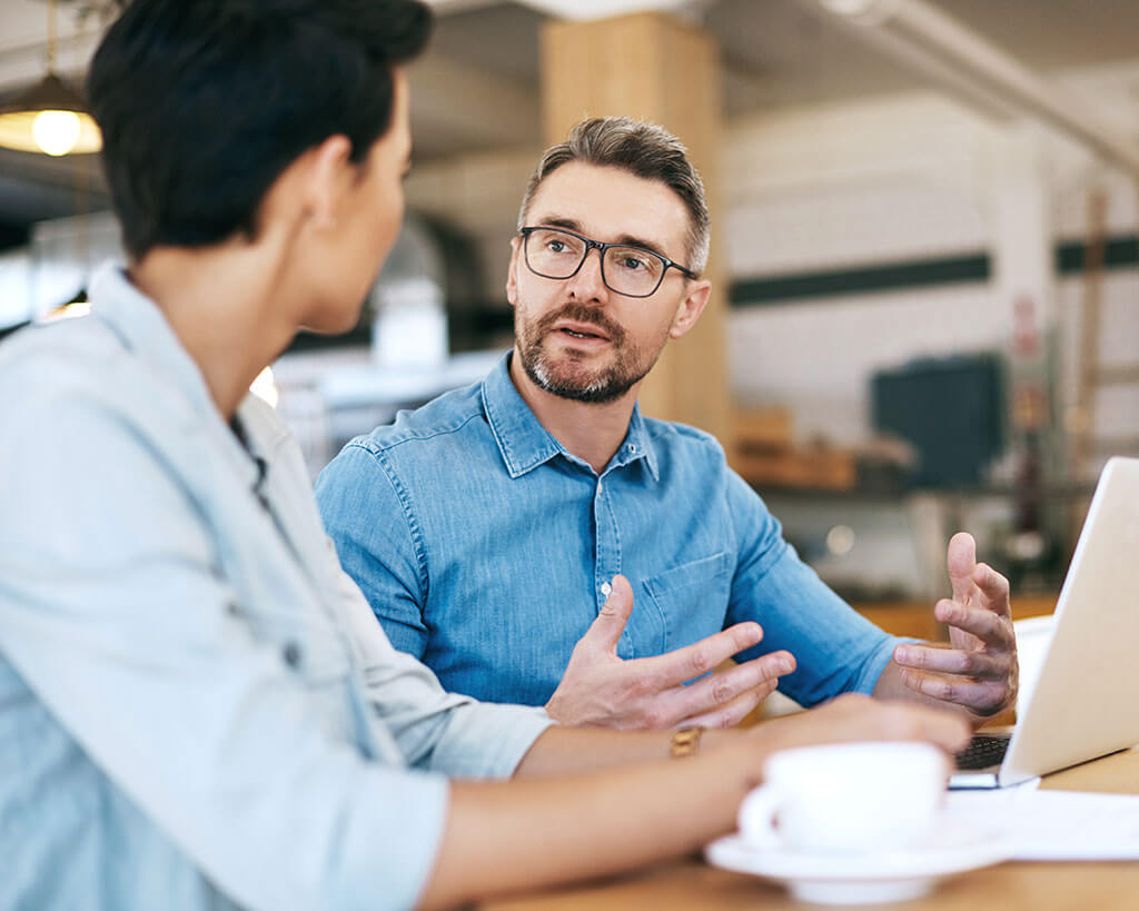 Two employees talking together while sitting