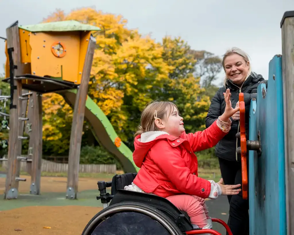 Woman with her handicapped daughter at a public park built with funding from the USDA Community Facilities Program