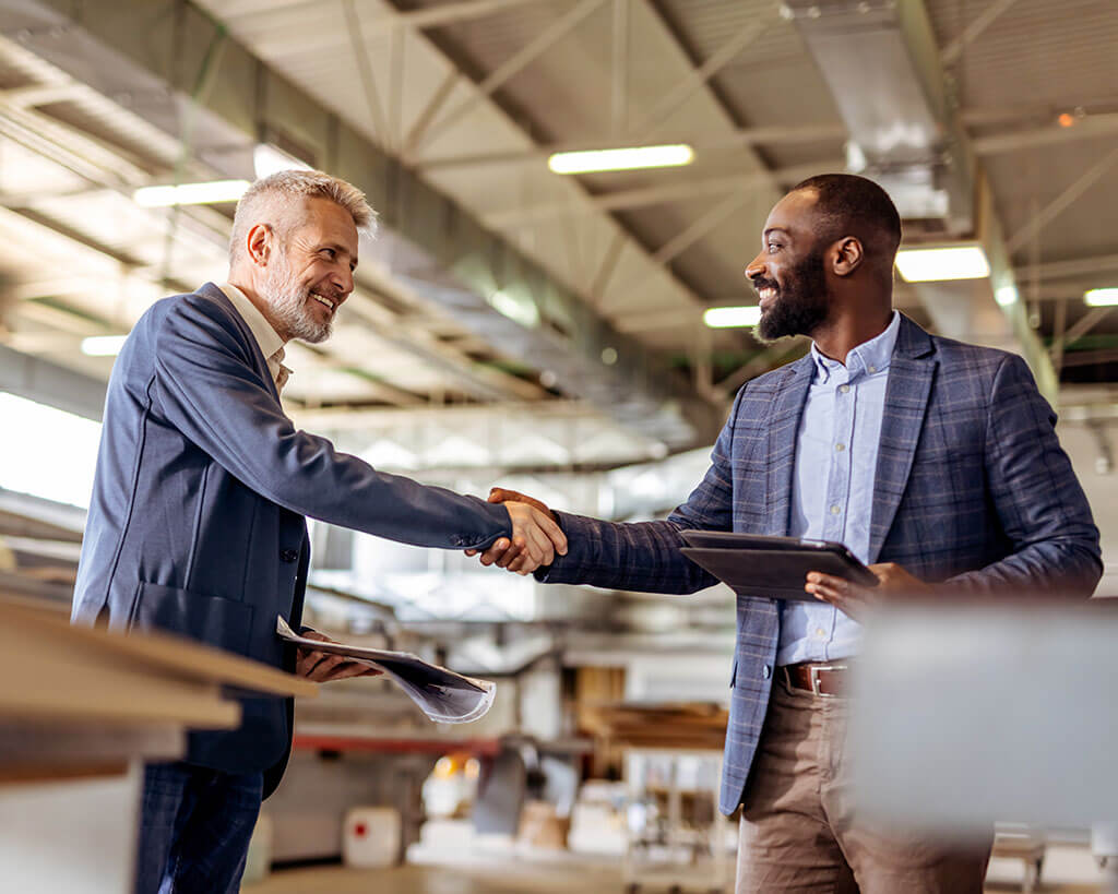 Two people shaking hands to agree on terms of a new business loan origination