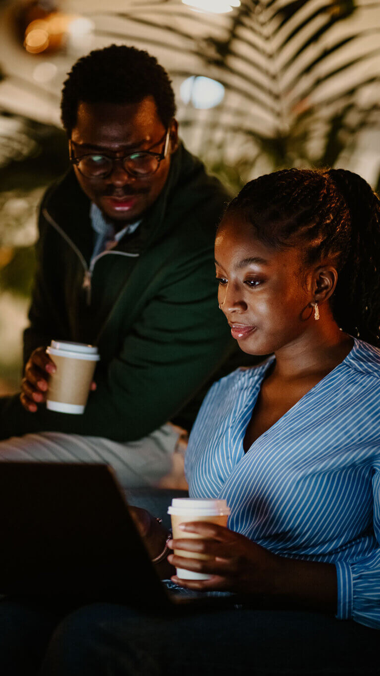 Two credit union employees researching commercial loan secondary market services