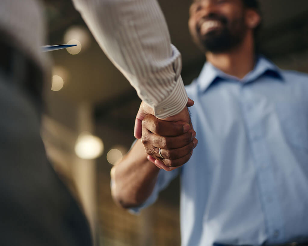 Two people shaking hands on a commercial loan syndication opportunity