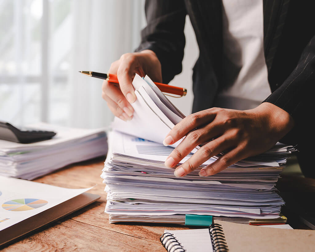 Business professional working through a stack of documents for business loan credit administration